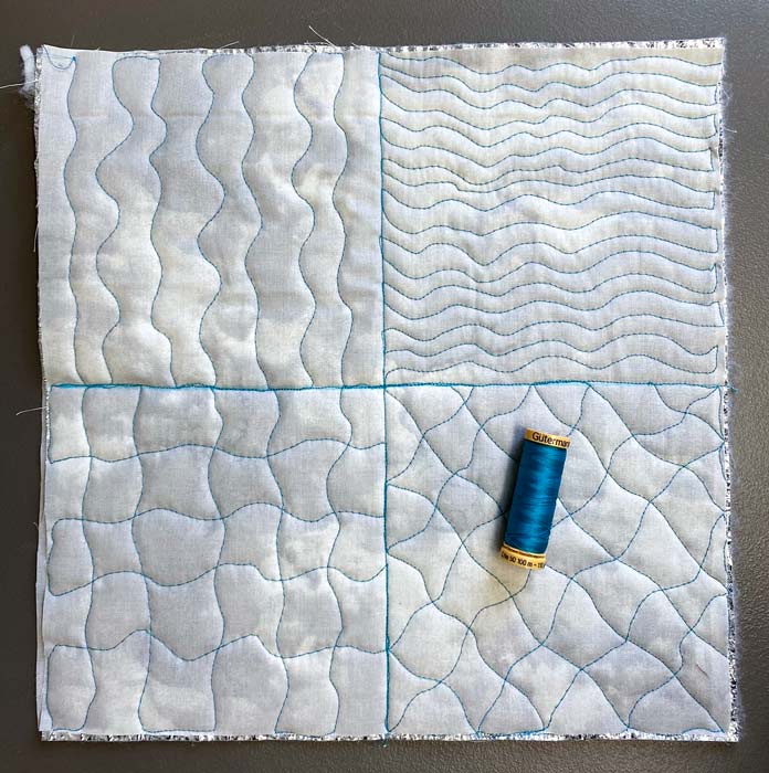 Four different wavy free motion quilt designs with a spool of teal thread lying on top; Gütermann Cotton Thread