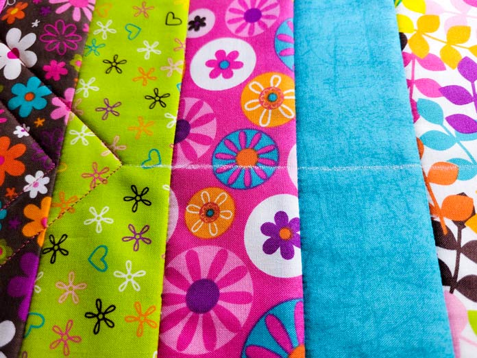 Green, pink, and blue floral fabric with a white chalk line through the center