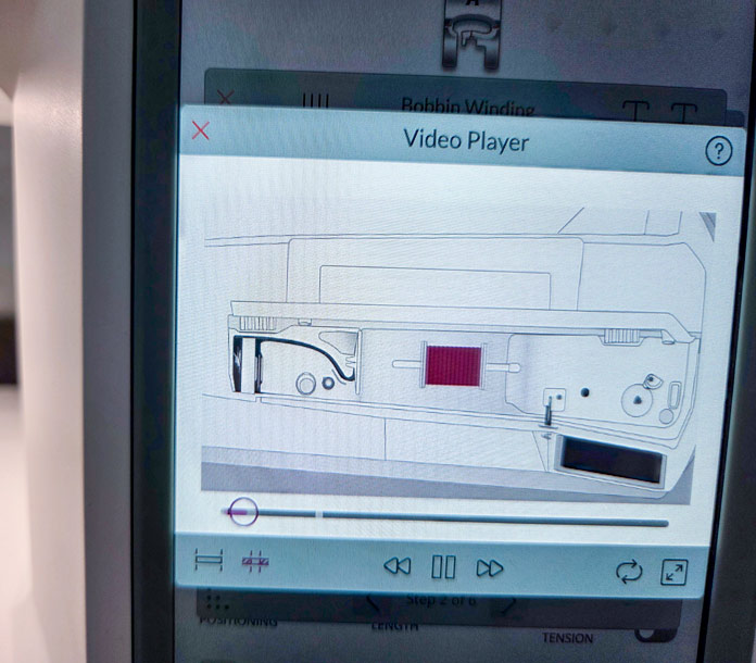 A video on the screen of a computerized sewing machine