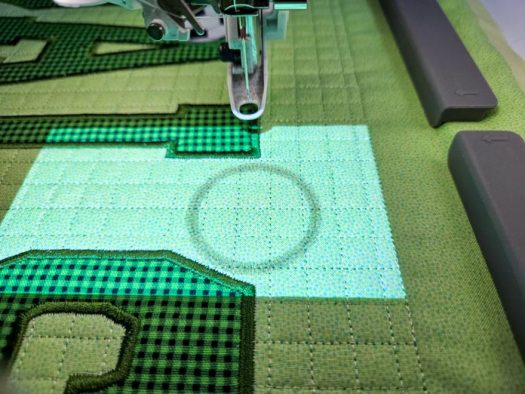 A dark circle in a highlighted window on green fabric