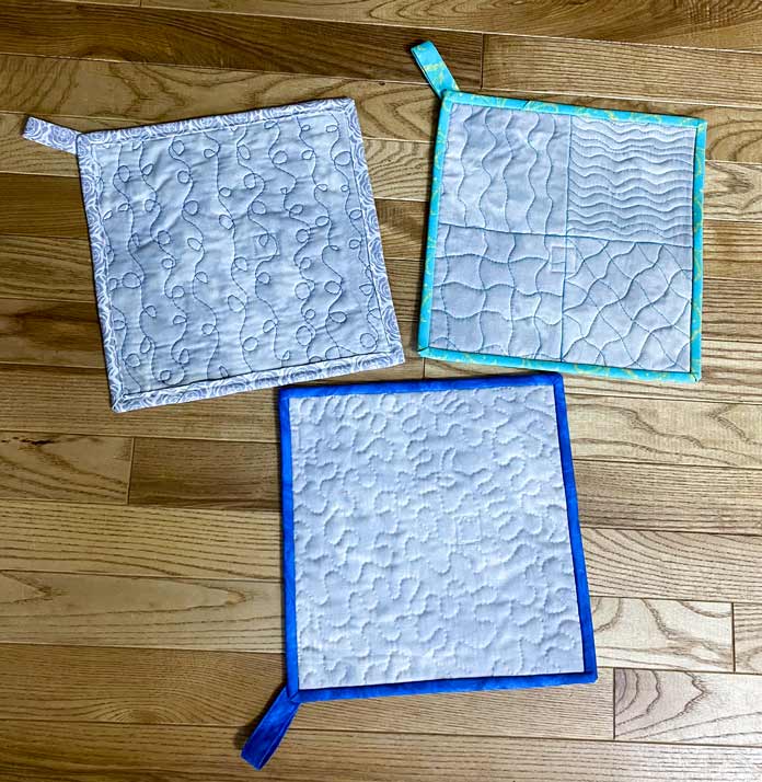 3 potholders with different quilting designs.