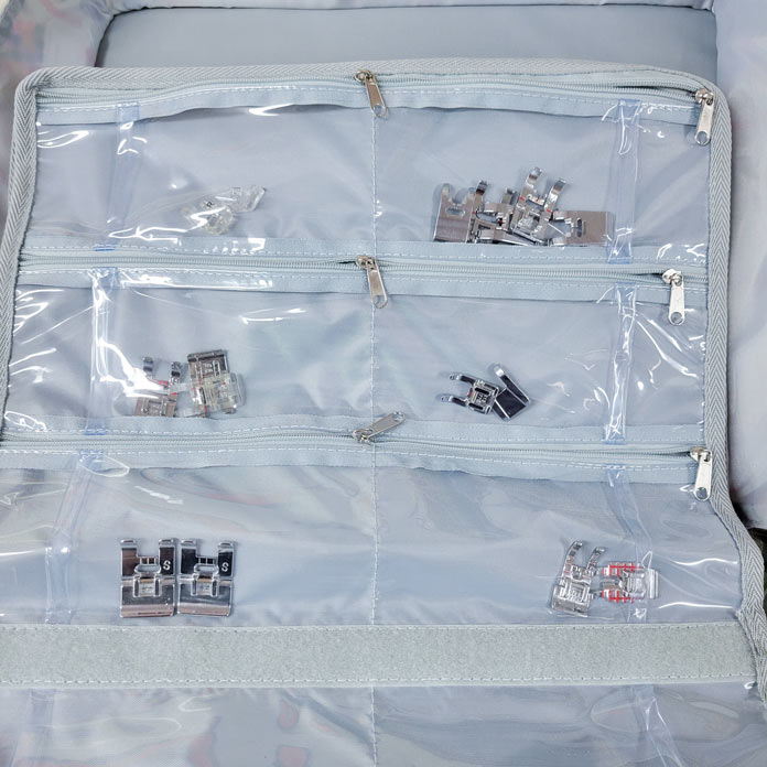 A clear pouch with zippered pockets holding metal sewing machine feet