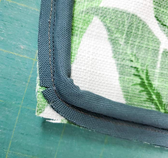 A piece of green piping sewn to a green and white fabric; Husqvarna Viking Designer Sapphire 85