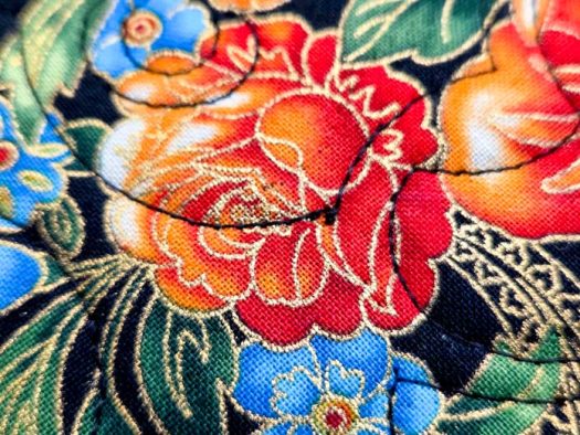 Black stitching on a floral fabric