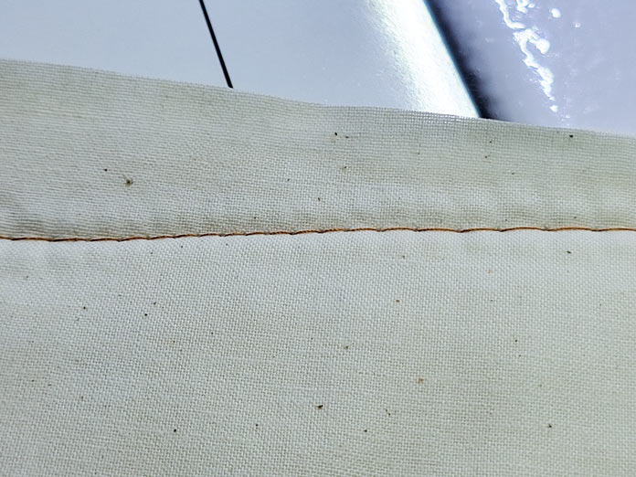 Basting stitches in brown thread on cream fabric; Husqvarna Viking PLATINUM™ Q160