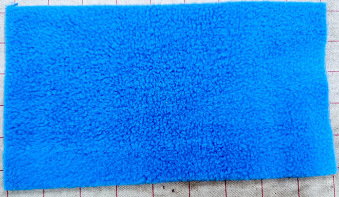 A piece of blue fleece; Learn how to use HeatnBond SOFTSTRETCH fusible web on knits, denim, fleece, and more