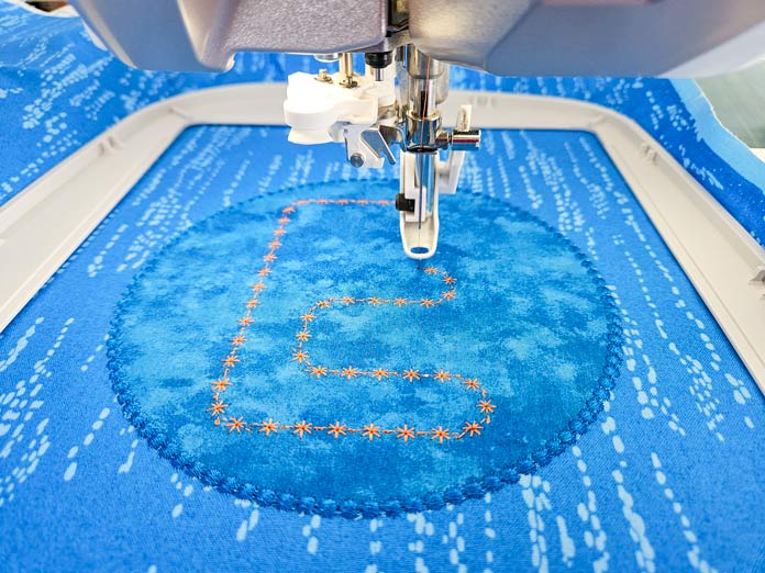 Orange stitching on blue fabric; HUSQVARNA VIKING, Designer Epic 3, embroidery machine, mySewnet, quilting, embroidery designs, sewing, applique, embroidery fonts, machine embroidery, stitch editing