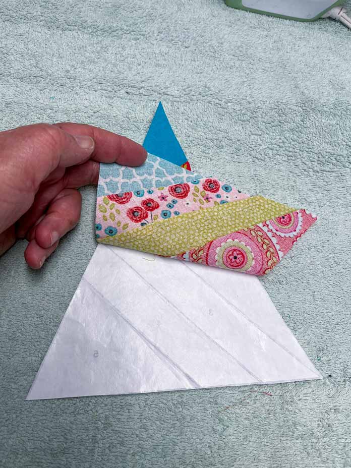 Peeling away freezer paper from triangle fabric