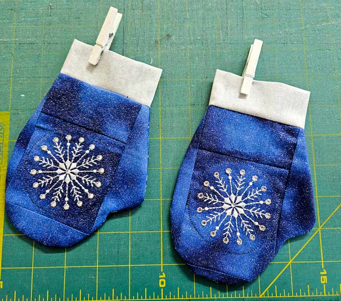 Two blue and silver mitten ornaments