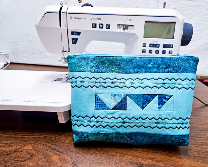 A blue pouch with a white sewing machine