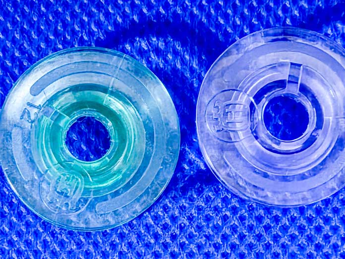 Two bobbins – one is green and one is purple