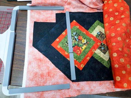 A black and green table runner in a magnetic machine embroidery hoop