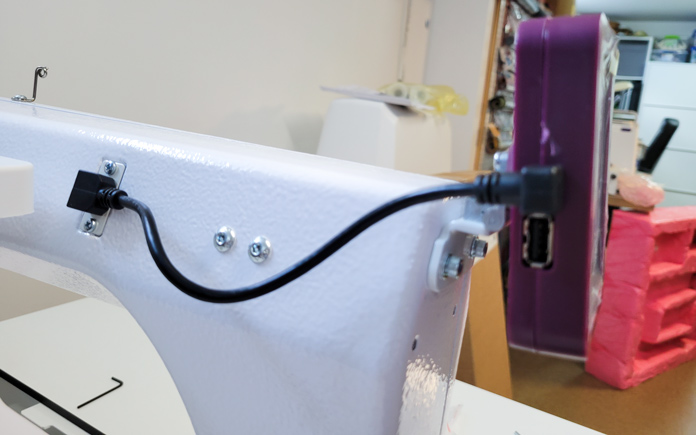 A short black cable connects the purple touch screen to the quilting machine; Husqvarna Viking PLATINUM™ Q160
