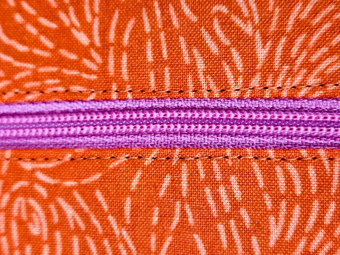 A pink zipper with orange fabric and orange topstitching; making a project bag on the Husqvarna VIKING ONYX 25