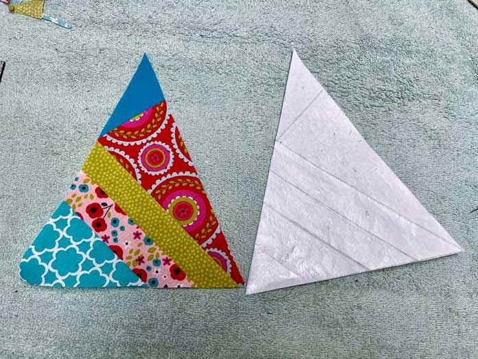 Freezer paper is peeled away and showing the triangle unit with all 5 fabrics