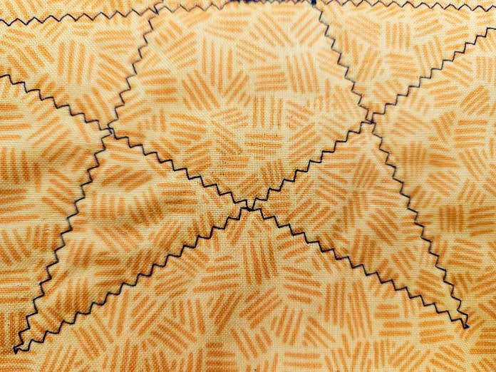 Blue zigzag lines in the shape of a star on yellow fabric