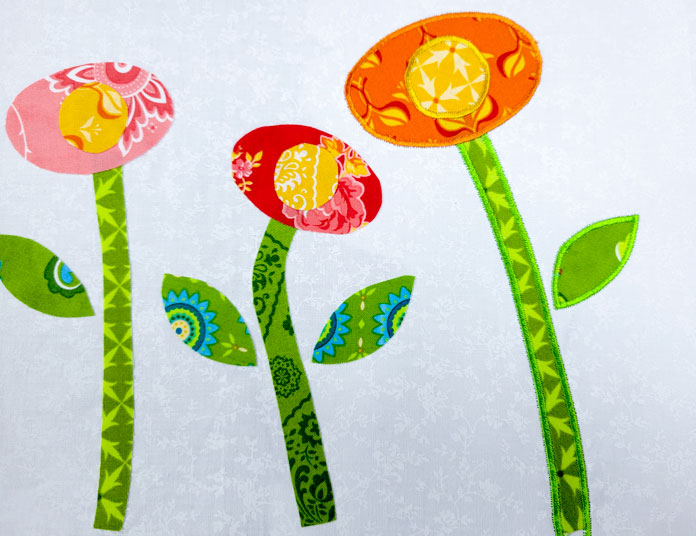 Three whimsical flowers with green leaves and pink and orange, and red flowers on a white background