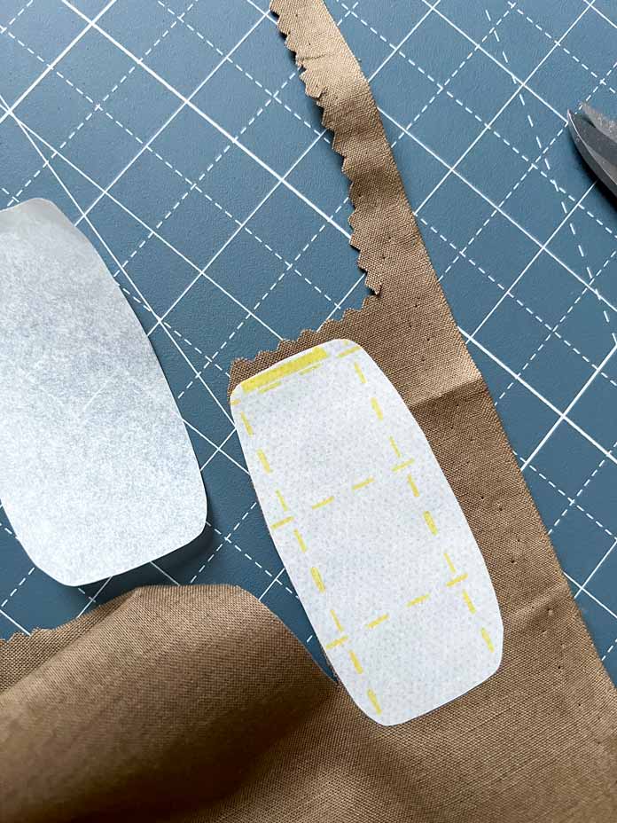 Cut the applique elements on a fusible web without adding a seam allowance. Remove the paper from one side of the web. Glue each element to the wrong side of the appropriate fabric. 