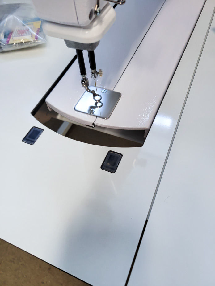 A gap between the white quilting machine and the white stitch regulator insert; Husqvarna Viking PLATINUM™ Q160