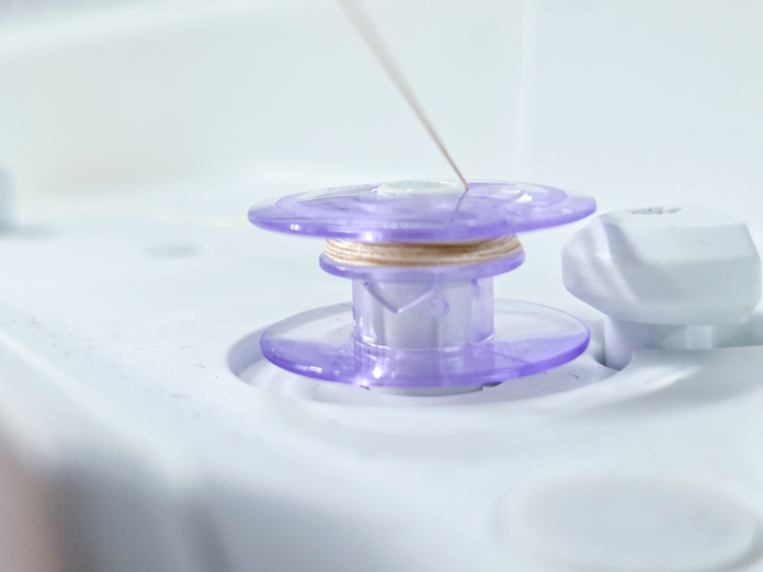 A purple bobbin with beige thread