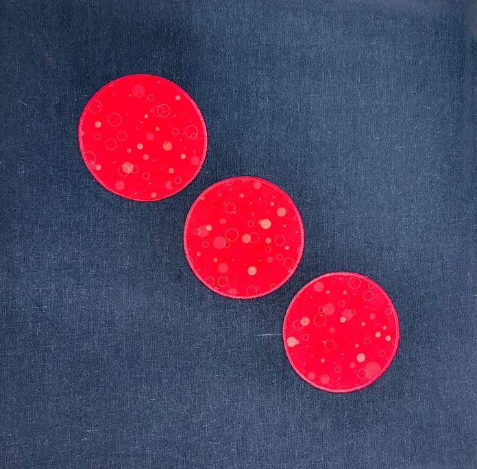 Three red circles on a black fabric