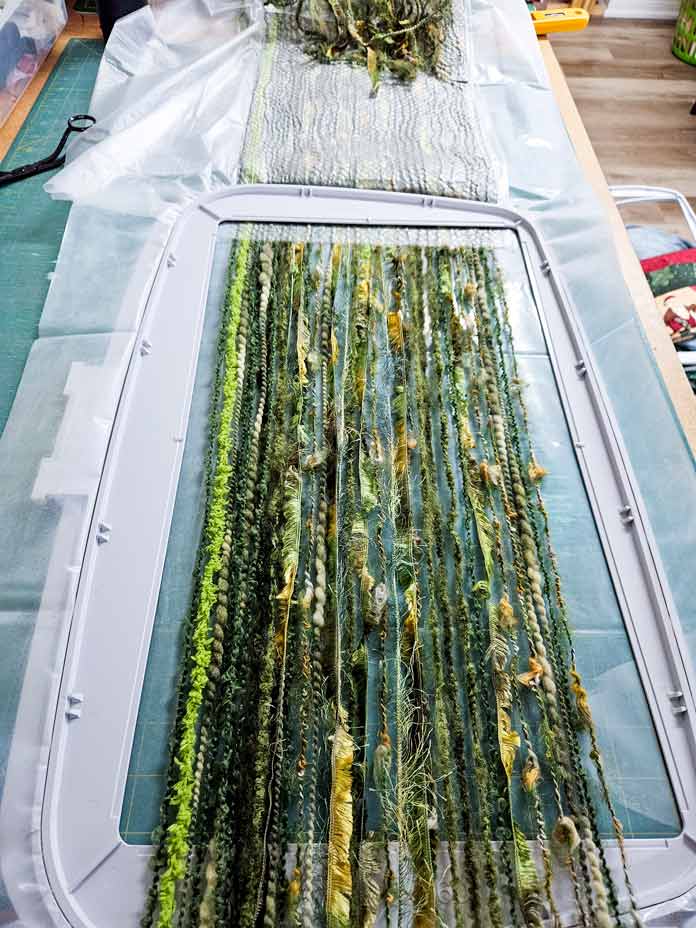 Green yarn in an embroidery hoop