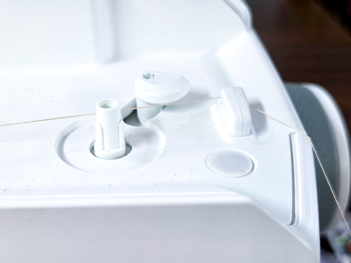 A thread cutter beside the bobbin winder on a sewing machine