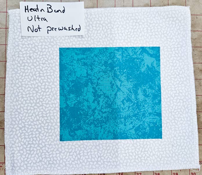 A square of teal fabric on white fabric; HeatnBond FeatherLite, fabric samples, fusible web, sewing projects