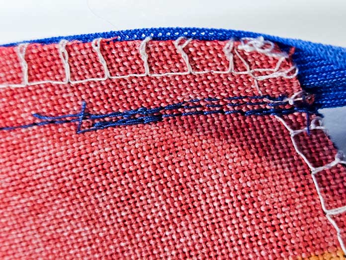 Lines of blue stitching on red fabric; Gütermann Nostalgia Box - 50wt Cotton Thread 100m - 48 Shades, Gütermann Nostalgia Box, Flat Felled Foot 9mm, Husqvarna VIKING Opal 690Q, free sewing pattern, outdoor accessories, outdoor cushions, piping, Husqvarna VIKING 8” Bent Trimmer