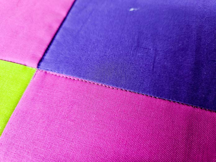 A bright-colored quilt with machine stitching