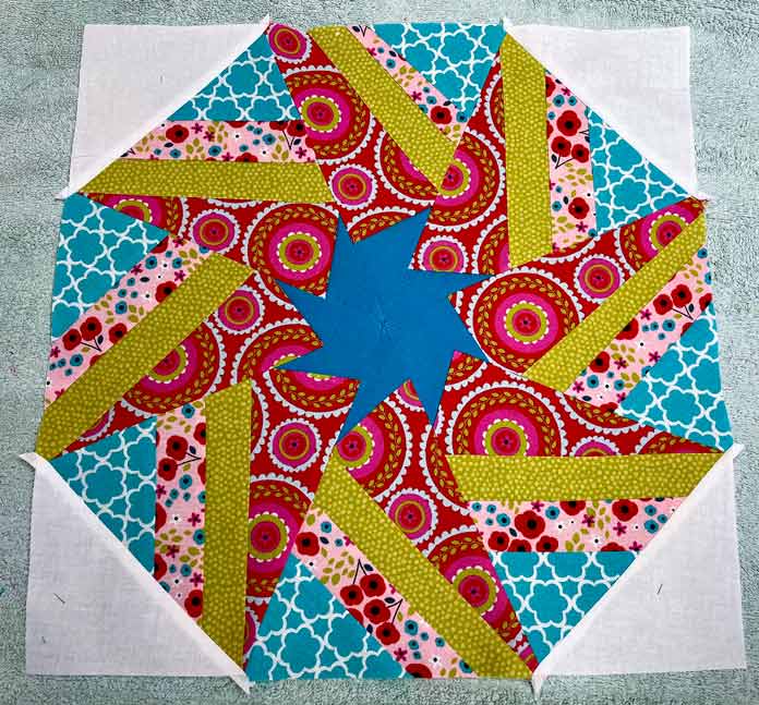 White corner triangles sewn to the colorful hexagon block