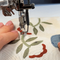Close-up of free motioning the raw edge applique elements with a PFAFF 6D Dynamic Spring Foot; cutting the thread; close up demoing the result on the right and wrong sides