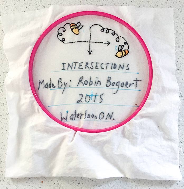 Bees are embroidered to quilt label for the Intersections Quilt.
