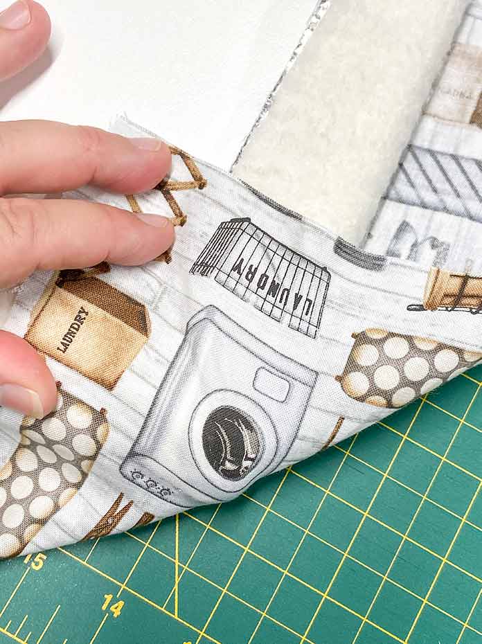  Fold the corners of the fabric to the back and then wrap the two adjacent edges around the corner before stapling. UNIQUE Wool Pressing Mat, Oliso M2Pro Mini Project Iron, Oliso Pro TG1600 Smart Iron, UNIQUE Quilting Therm Fleece, Fairfield Toasty Cotton Natural Cotton Quilt Batting