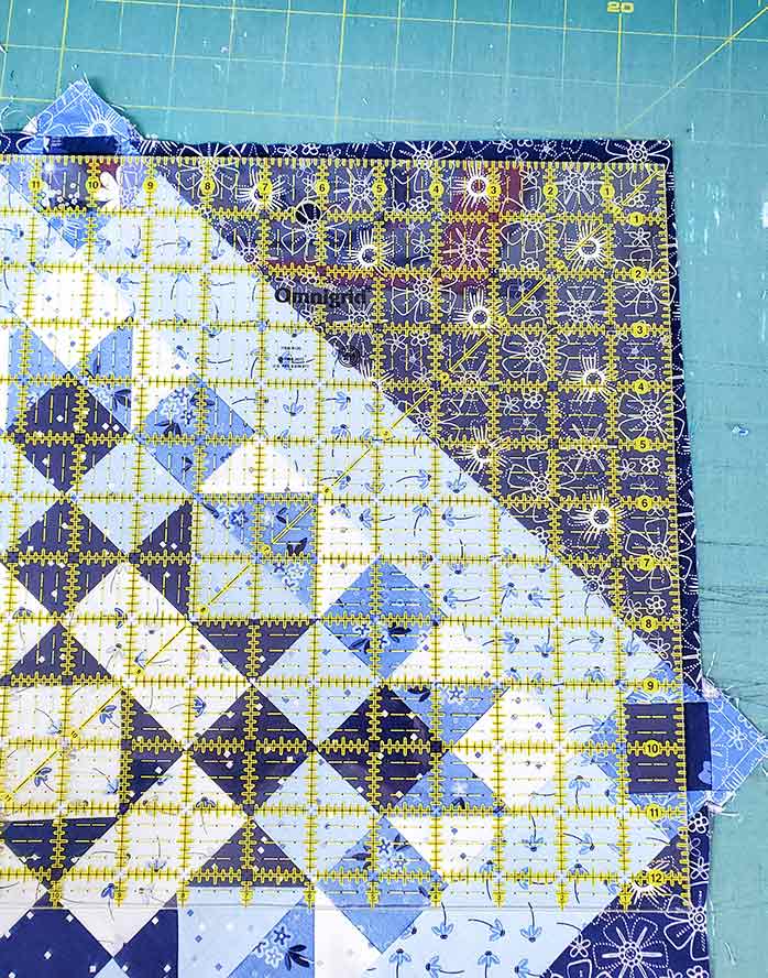 Trim the corners of the blue and white quilt top. Spectrum QAL2020 made with the Blue Stitch collection by Riley Blake Designs 