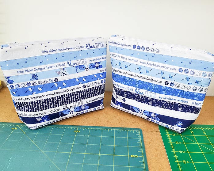 Two zippered pouches made with the selvages from the Blue Stitch collection by Riley Blake Designs. Blue Stitch collection by Riley Blake Designs, Husqvarna Viking EPIC2 sewing and embroidery machine, Husqvarna Viking Open Toe Foot, Singer Steam Press ESP2
