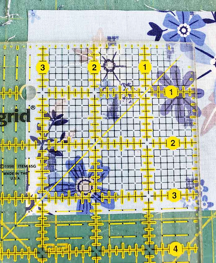 Cutting a quilt square at 35/16" inch using a square ruler. Block 3 with Blue Stitch fabric collection by Riley Blake Designs.