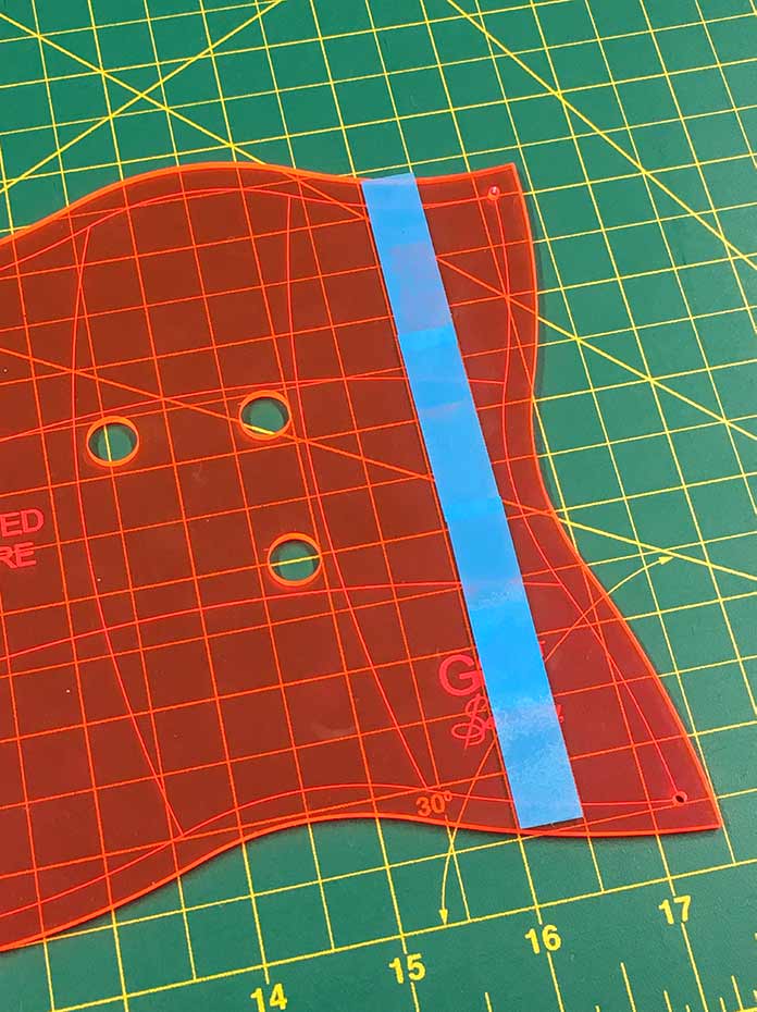 The cutting guide is marked on the curved template using tape or small sticky notes.