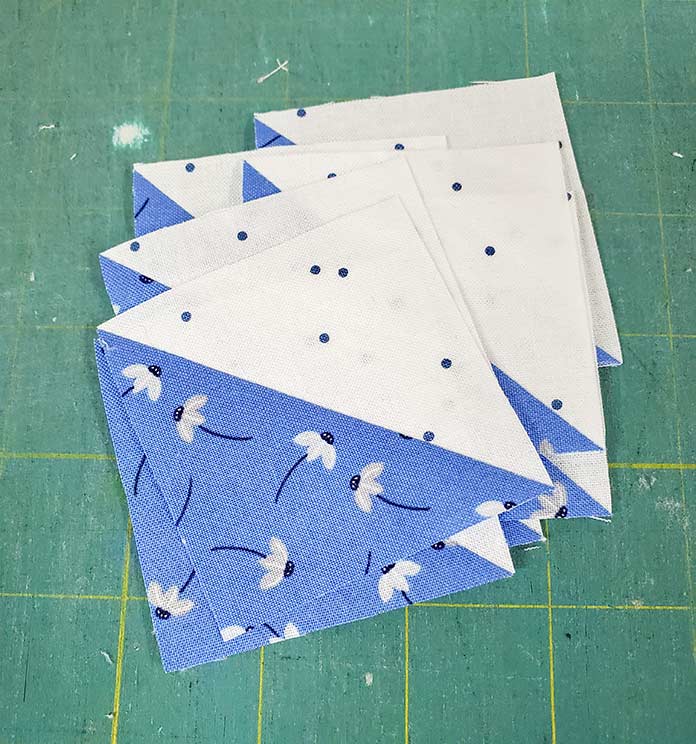 Blue and white half-square triangles from Block 4 featuring fabric from the Blue Stitch collection by Riley Blake Designs.