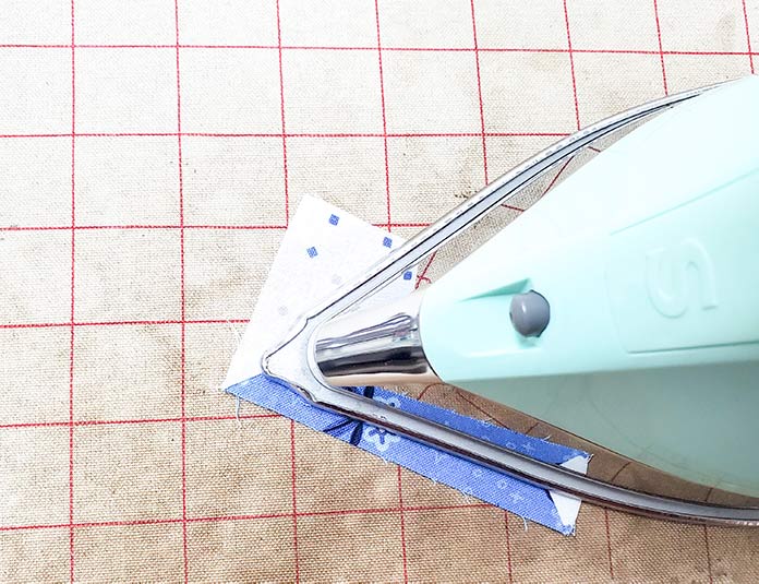 Pressing the blue and white quilt block made with the Blue Stitch collection by Riley Blake Designs using a green iron. Block 10 of the Spectrum QAL 2020 made with the Blue Stitch collection by Riley Blake Designs.