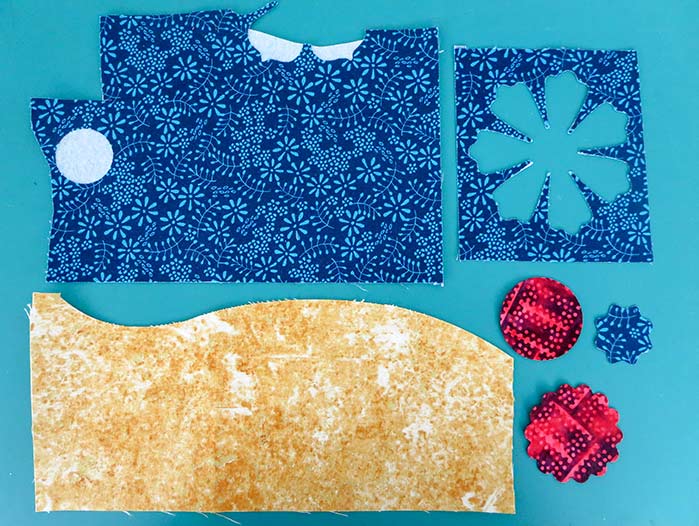 Fabric scraps backed with HeatnBond Featherlite fusible web; HeatnBond Featherlite, SCHMETZ nonstick needles, Olfa frosted ruler, Olfa scallop blade for rotary cutter, HeatnBond fusible fleece, HeatnBond fusible interfacing, Sulky variegated thread, Mary Ellen’s Best Press