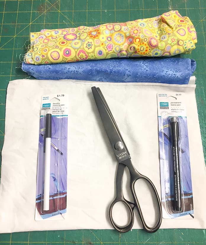 Supplies gathered for quilt labels made with UNIQUE Sewing Permanent Fabric Marking Pen and Laundering Pen. LDH pinking shears 