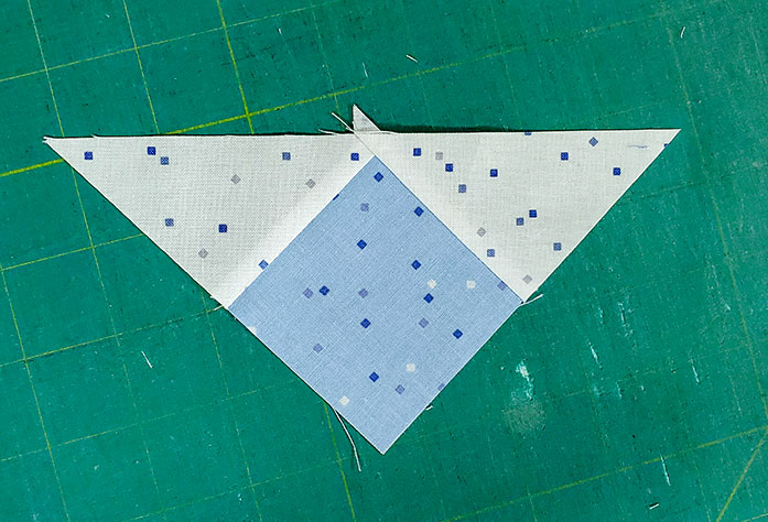 The pieced triangle for the center of the flying geese unit using the Blue Stitch collection by Riley Blake Designs