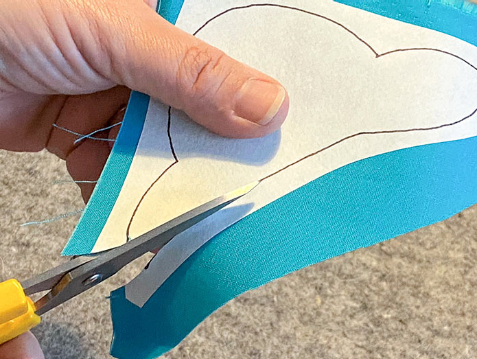 Use sharp scissors like the OLFA 5" Stainless Steel Serrated Edge Scissors to cut each of the shapes along the drawn lines. Mary Ellen’s Best Press, HeatnBond Lite Iron-On Adhesive Sheets, Olfa 5" Stainless Steel Serrated Edge Scissors, Heirloom Non-Stick Teflon Applique Mat, Oliso M2Pro Mini Project Iron.