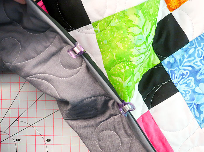 The binding is folded towards the back of the quilt and held in place with Clever Clips until it is ready to be sewn