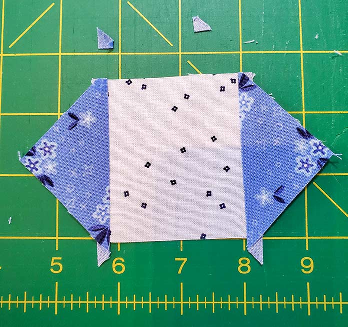 Trimming the dog ears from the square in a square unit made for Block 12 of the Spectrum QAL 2020 made with Blue Stitch collection by Riley Blake Designs