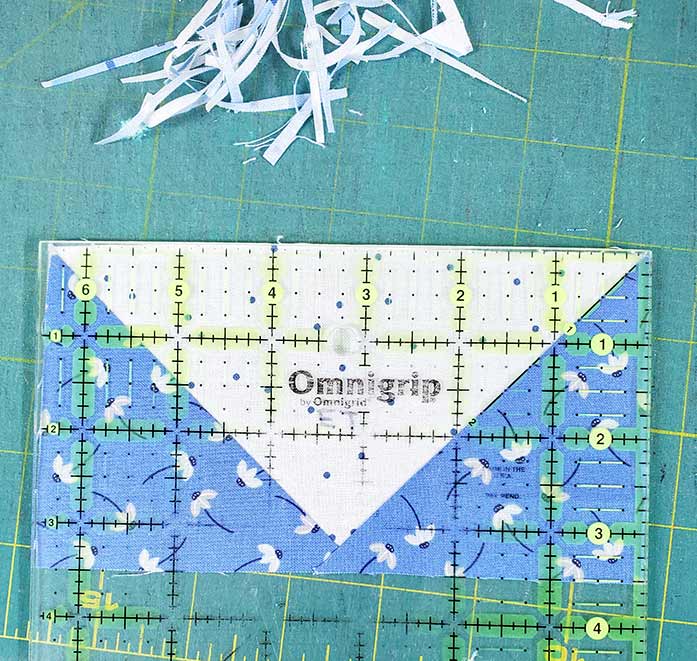 Trimming the flying geese units with a quilter's ruler. Block 4 featuring fabric from the Blue Stitch collection by Riley Blake Designs.