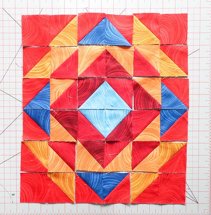 Place each sewn HST pair into their proper spot according to the layout diagram again before sewing them together into rows. Block 3 Spectrum QAL 2020 quilt design featuring fabrics from the Wave Texture collection by Benartex.