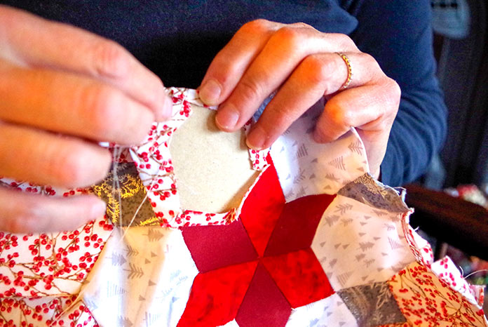 Holding the hexies together as they are hand sewn to make the table topper.  
