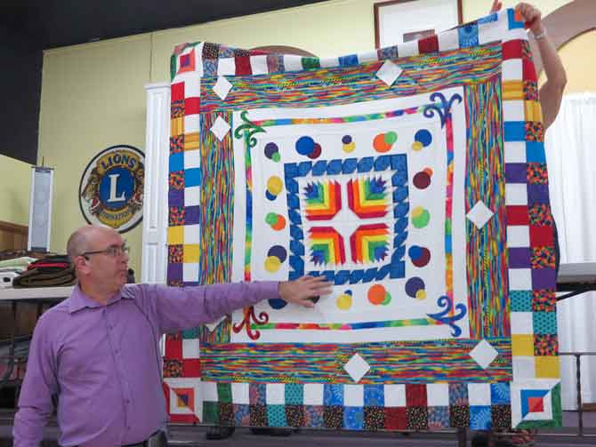 Paul presenting one of his quilts during a trunk show.